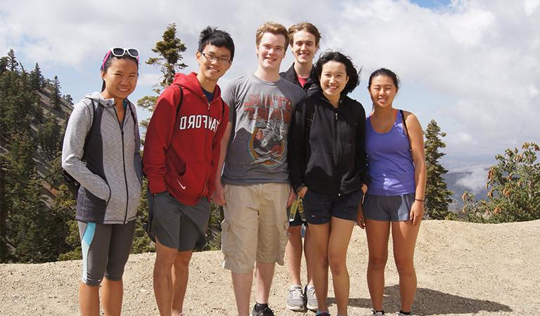 Students posing for a photo on top of a mountain.